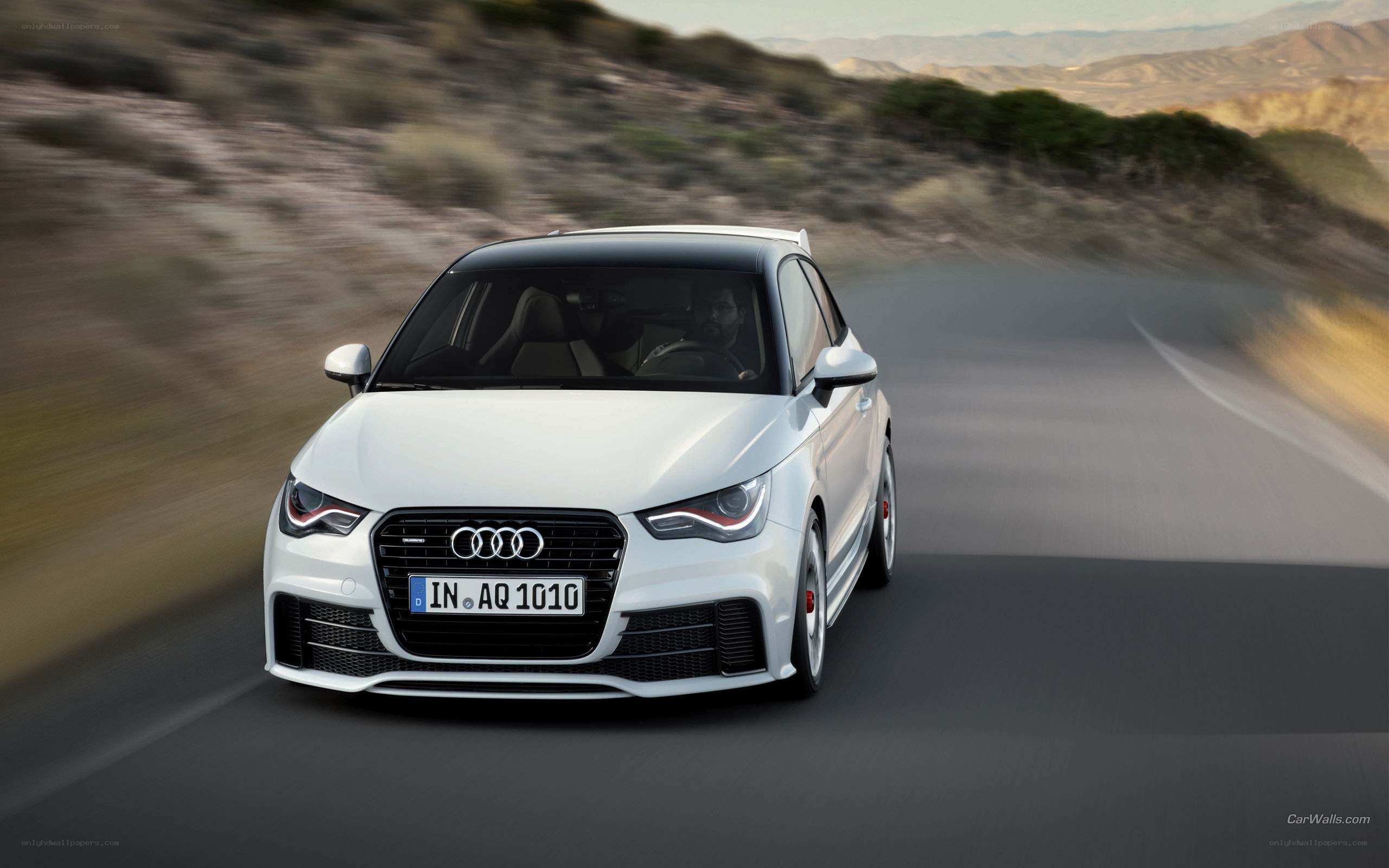 white audi a1 driving on road