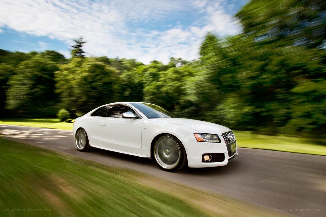 White Audi driving on a road