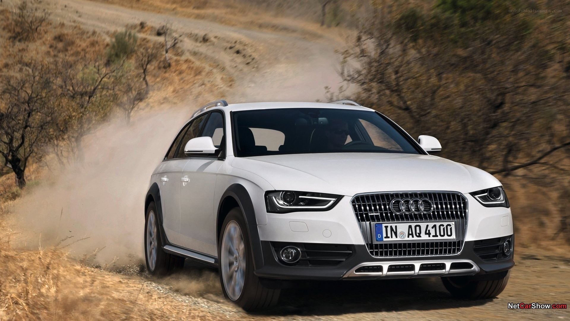 white audi driving on dirt road