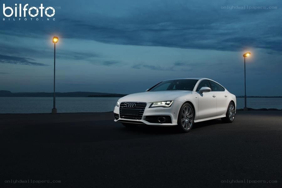 White Audi on a waterfront at dusk