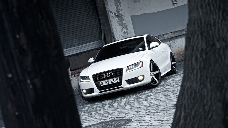 white audi parked on cobblestone