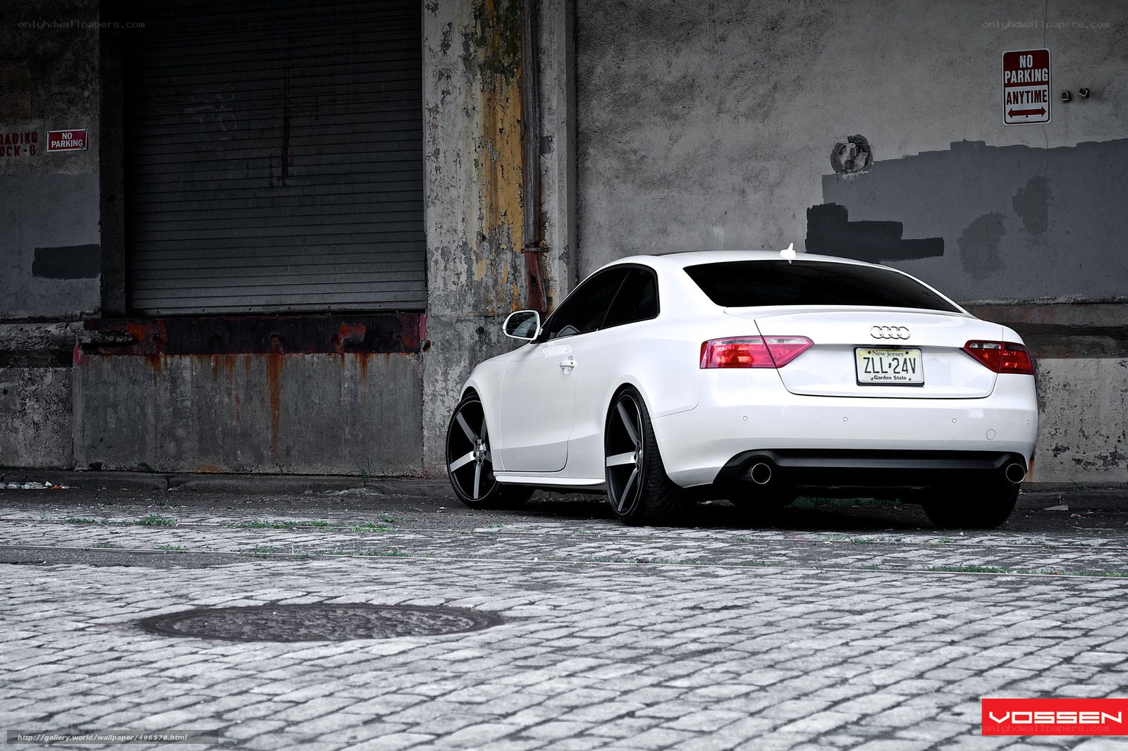 White Audi parked on cobblestones