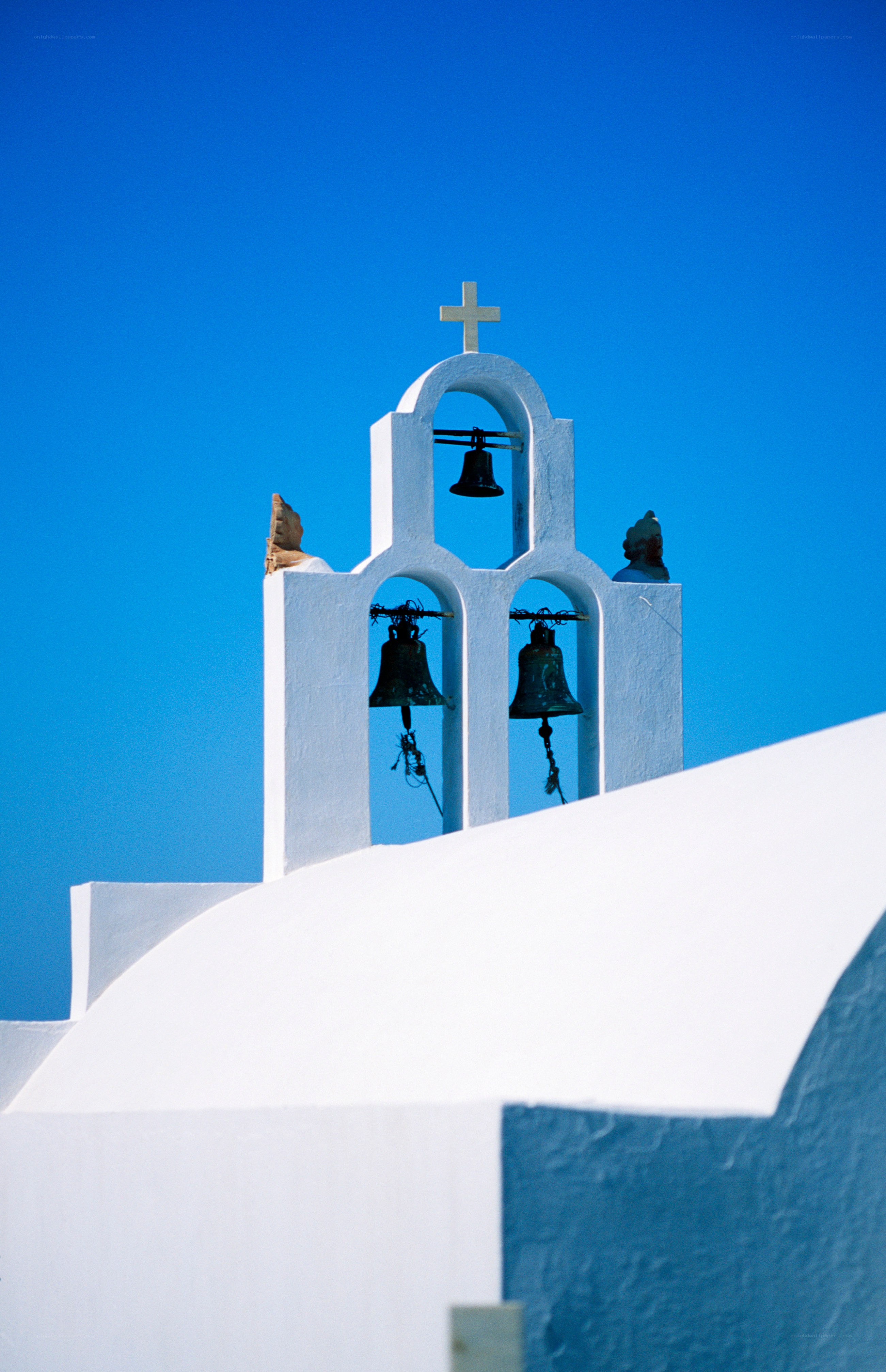 White bell tower against blue sky