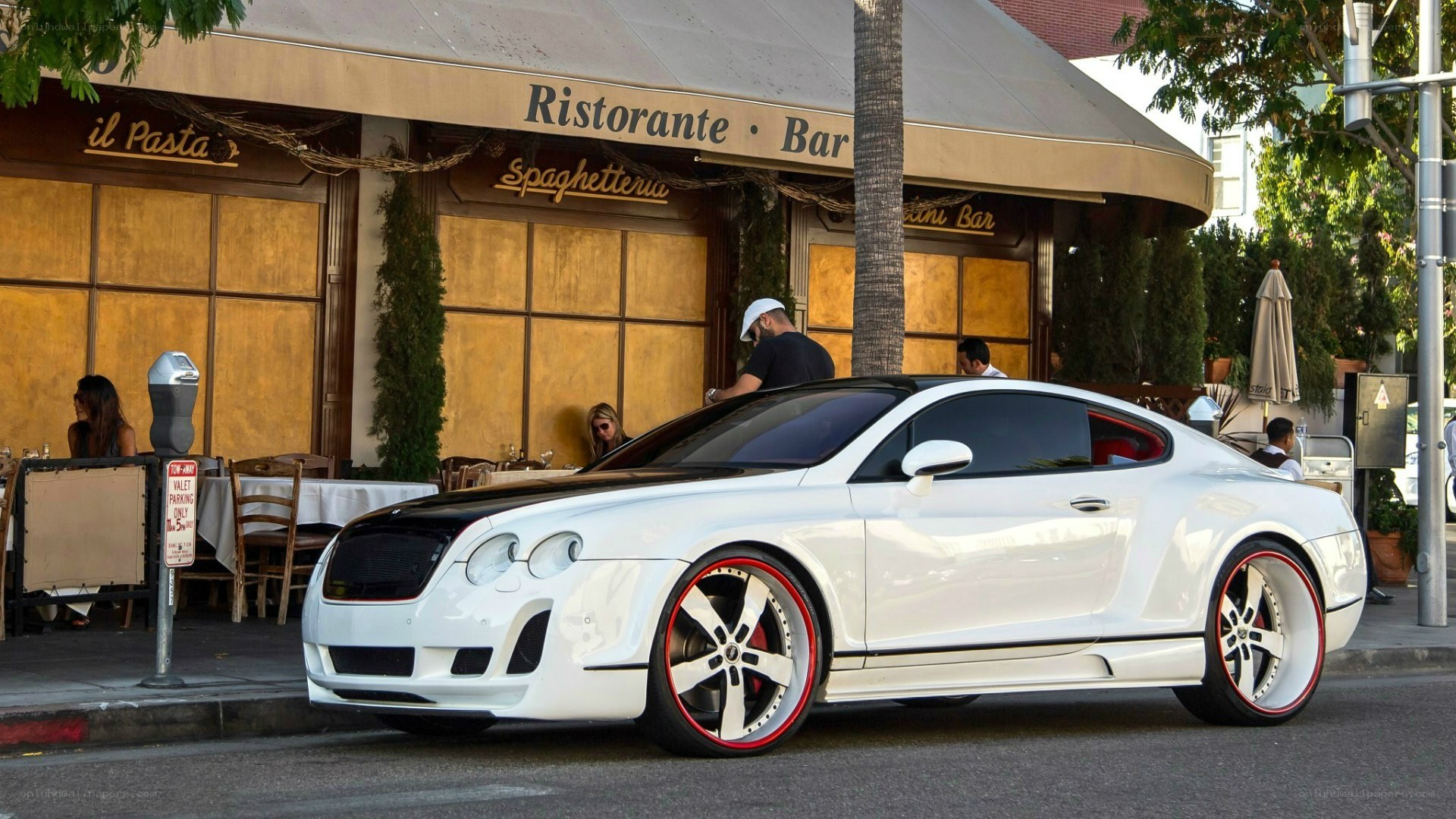 White Bentley parked outside a restaurant