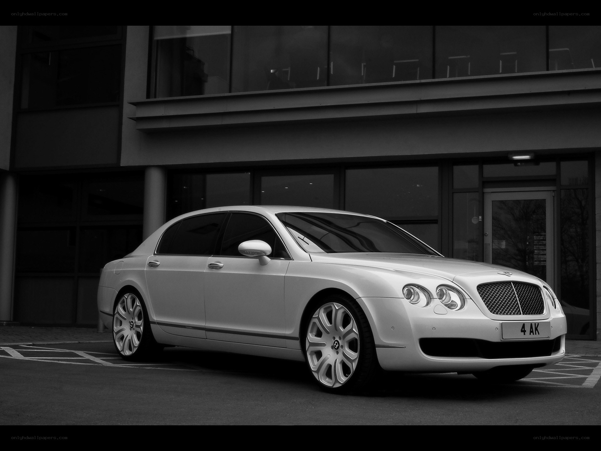 White Bentley parked outside building