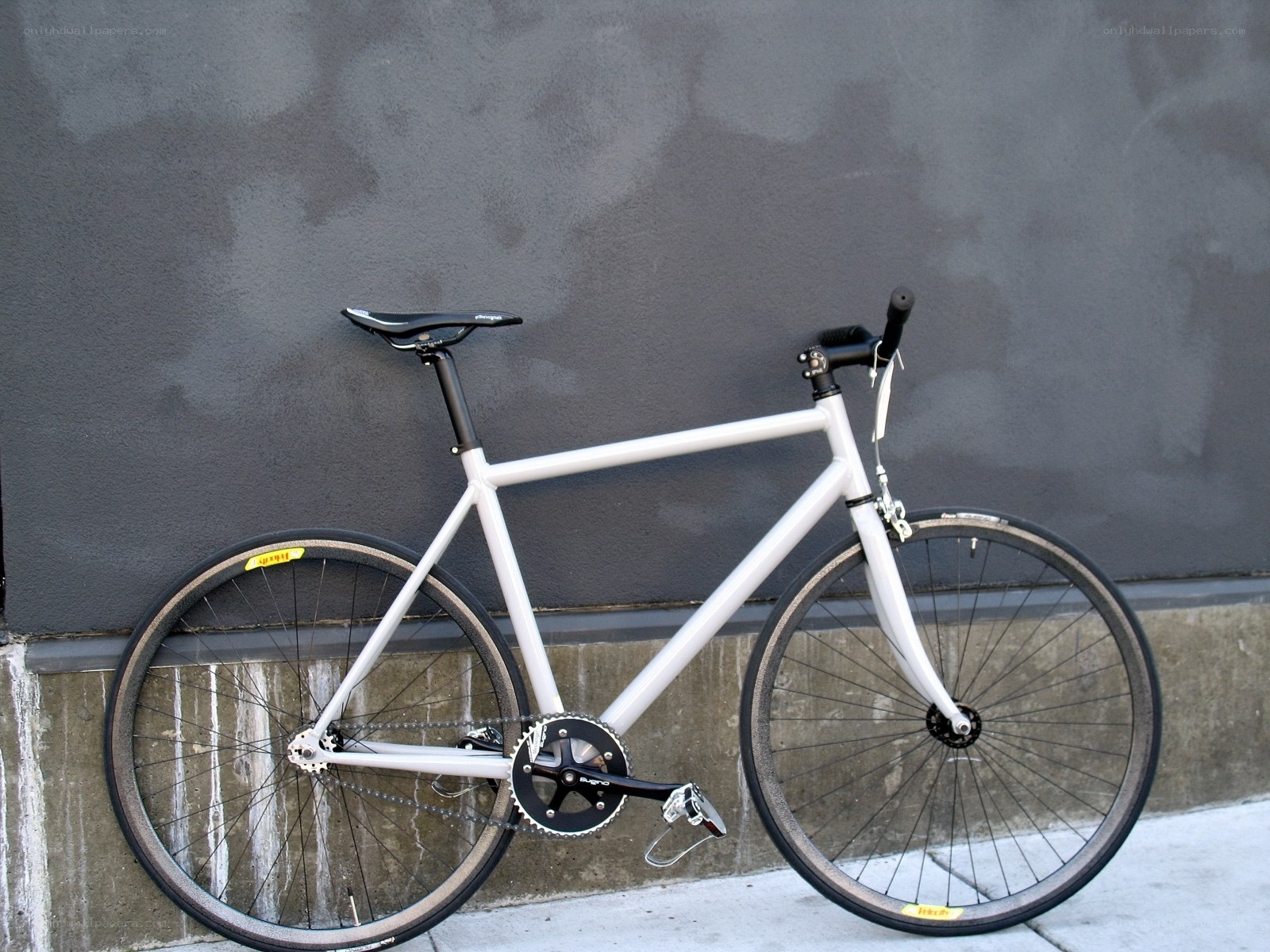 white bicycle against gray wall