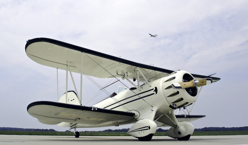 white biplane on tarmac