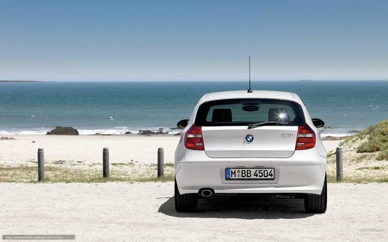 White BMW 120i by the beach