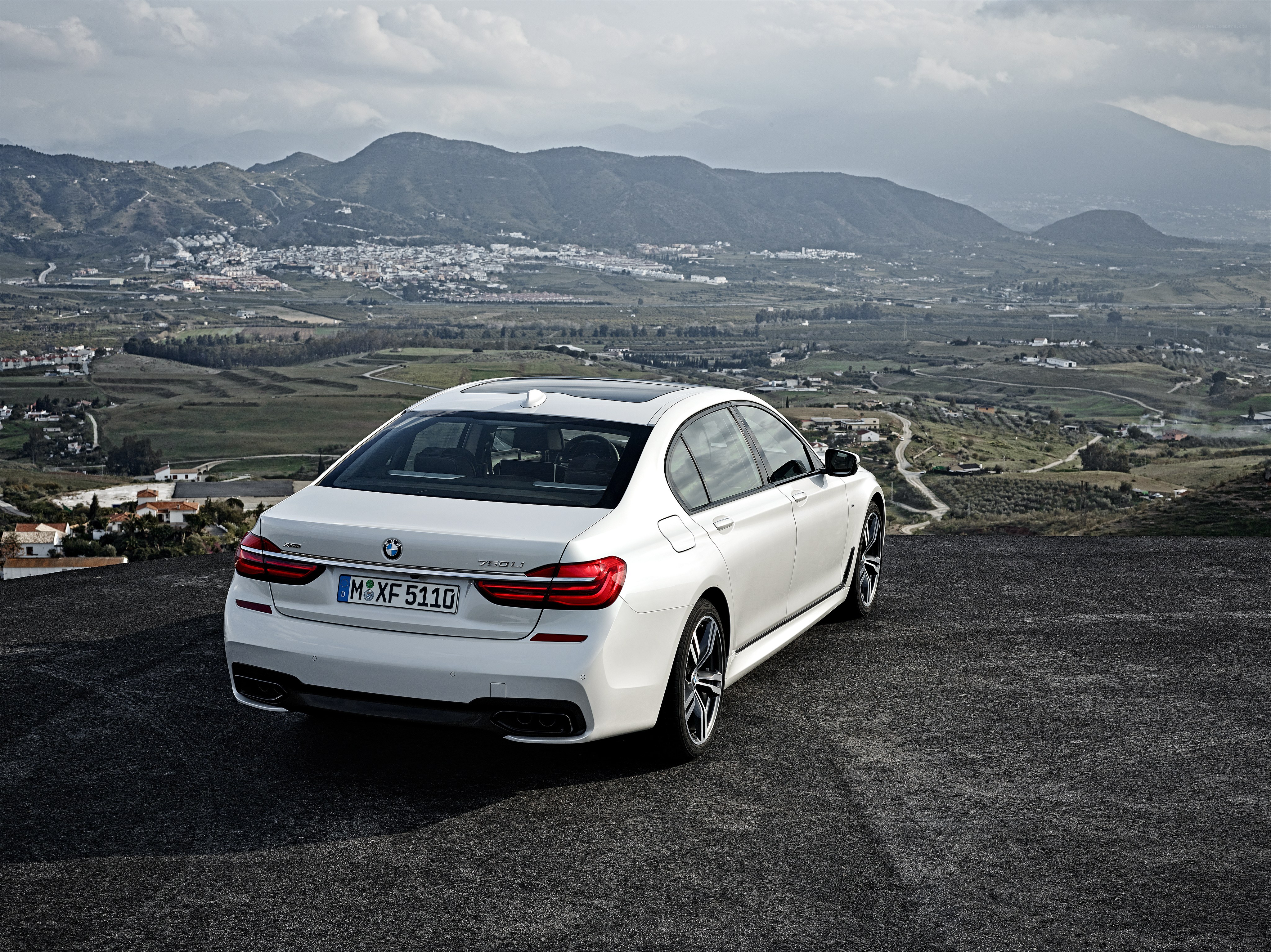 White BMW 750i on a mountain overlook