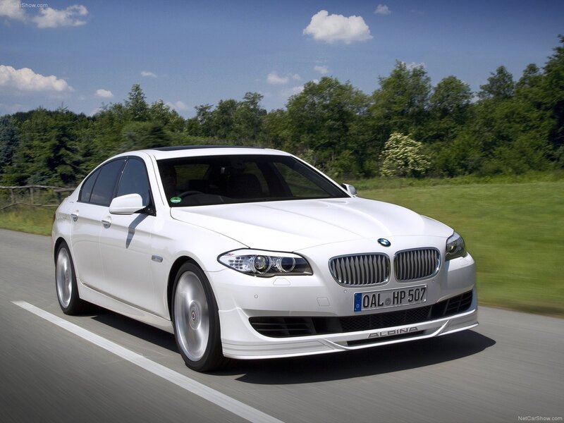 white bmw alpina driving on road