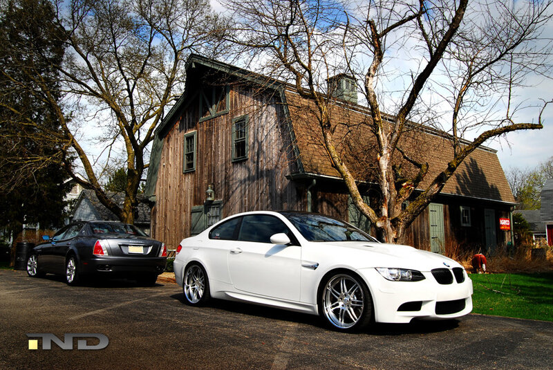 White BMW and black sedan parked
