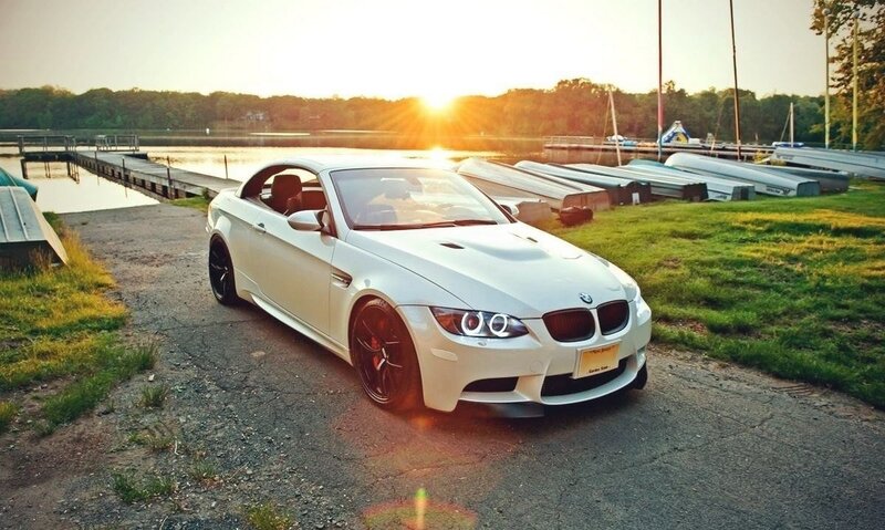 White BMW at sunset by the lake