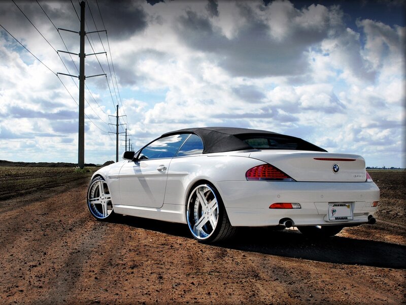 White BMW convertible on dirt road