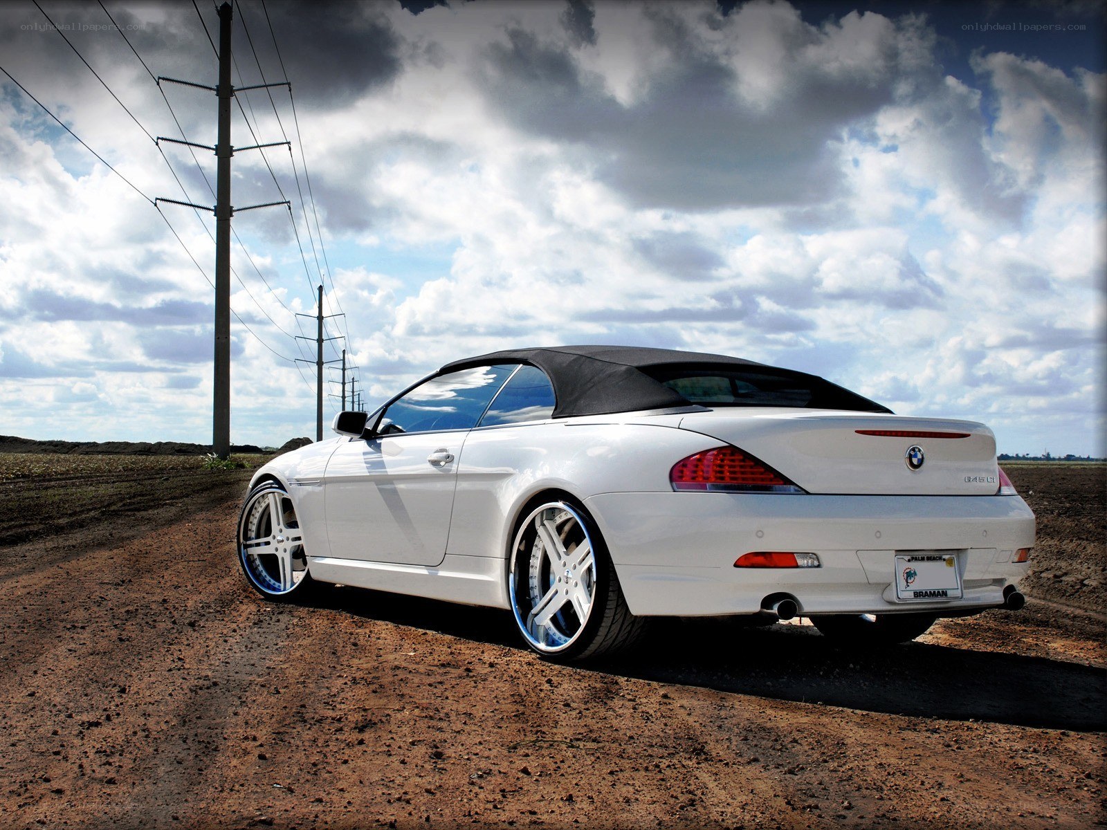White BMW convertible on dirt road