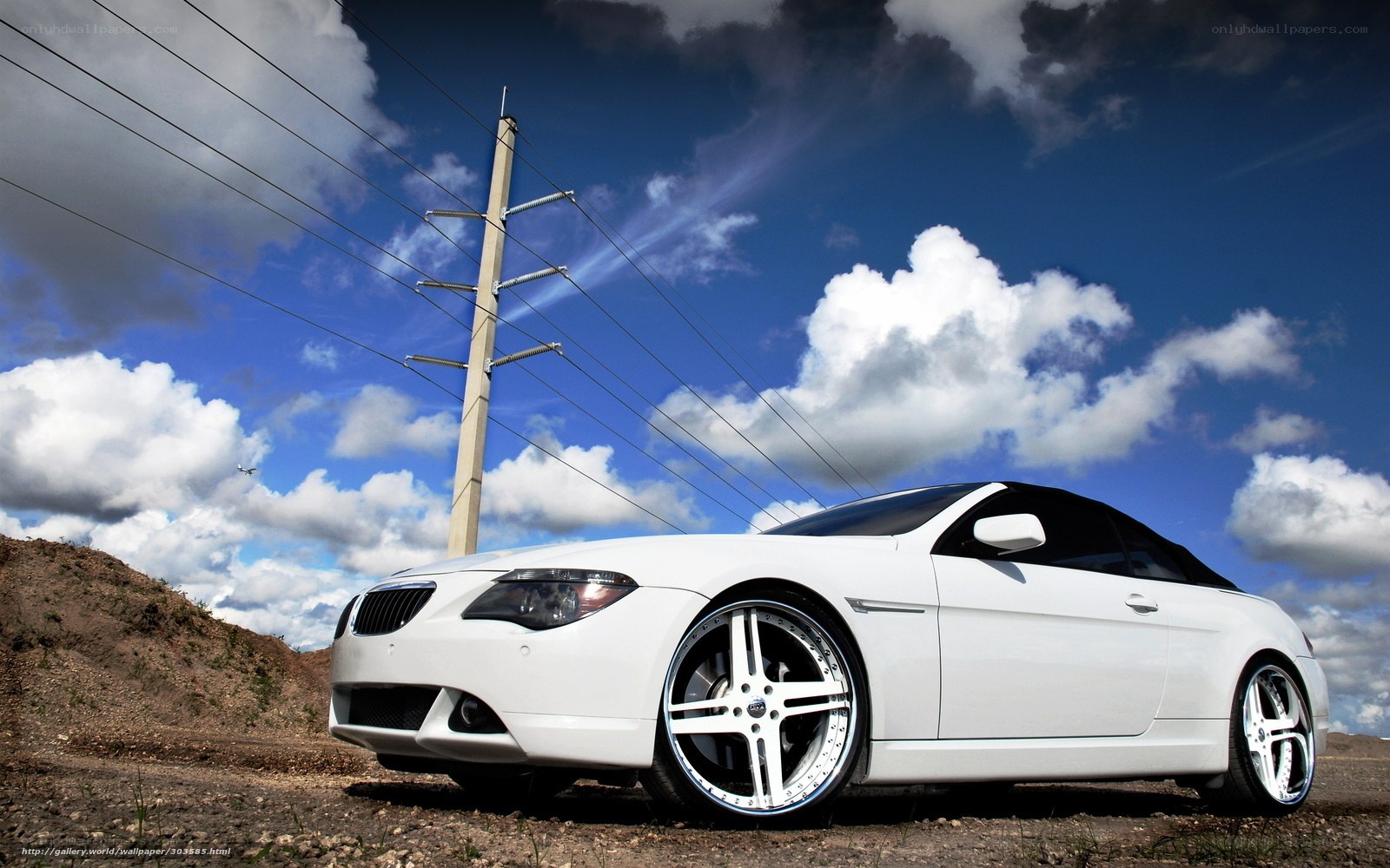 White BMW convertible on dirt road