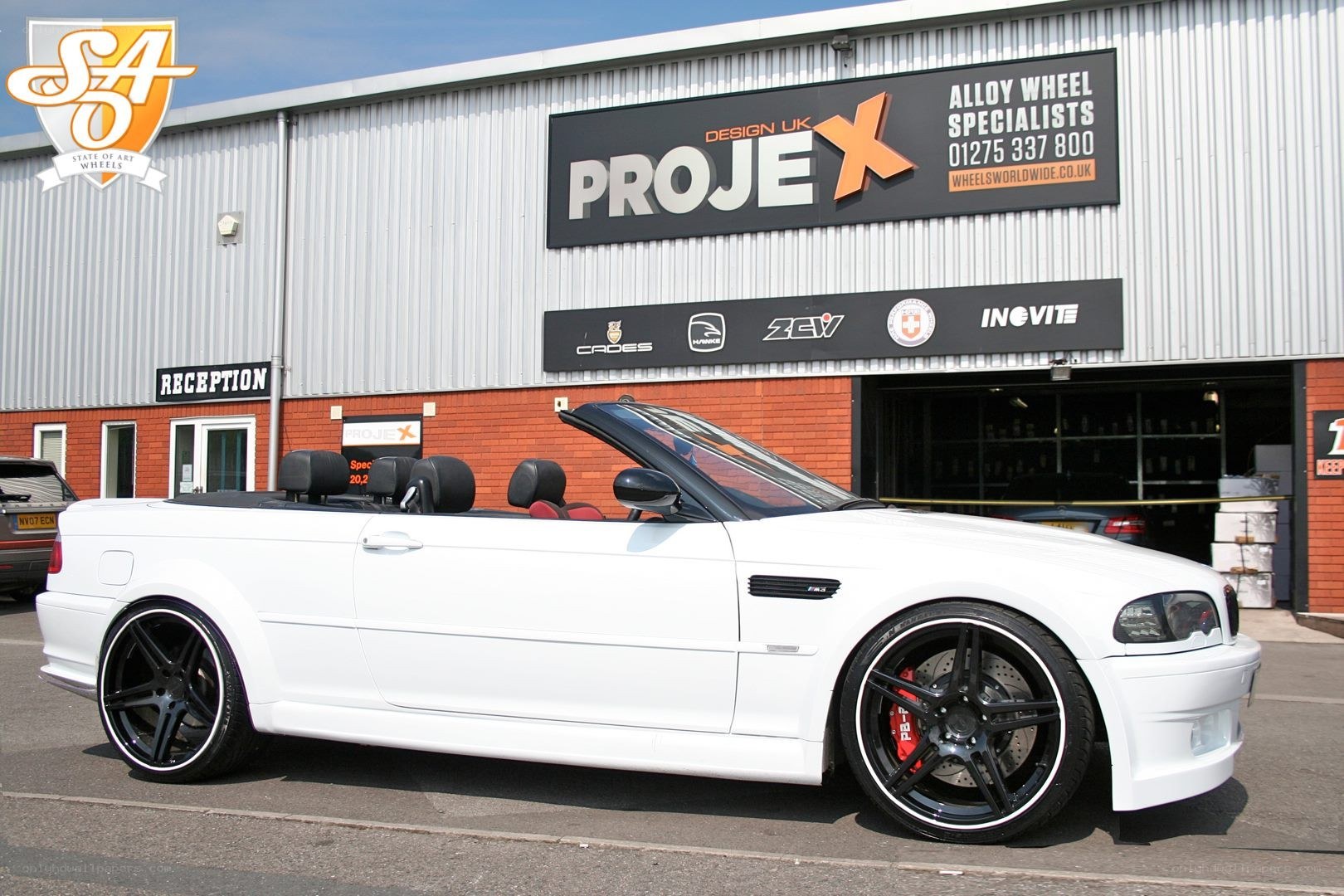 White BMW convertible outside wheel shop