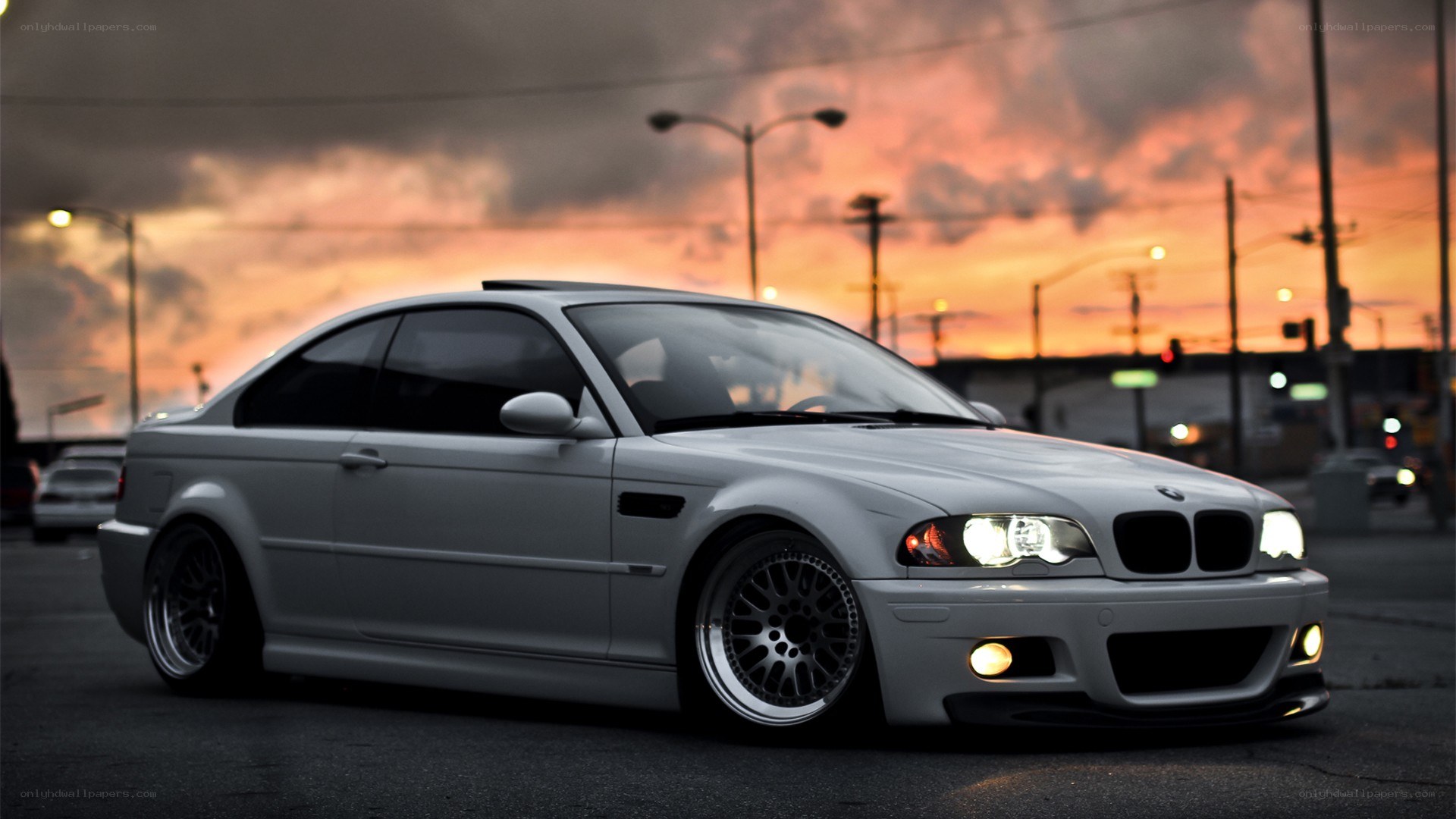 white bmw coupe at sunset