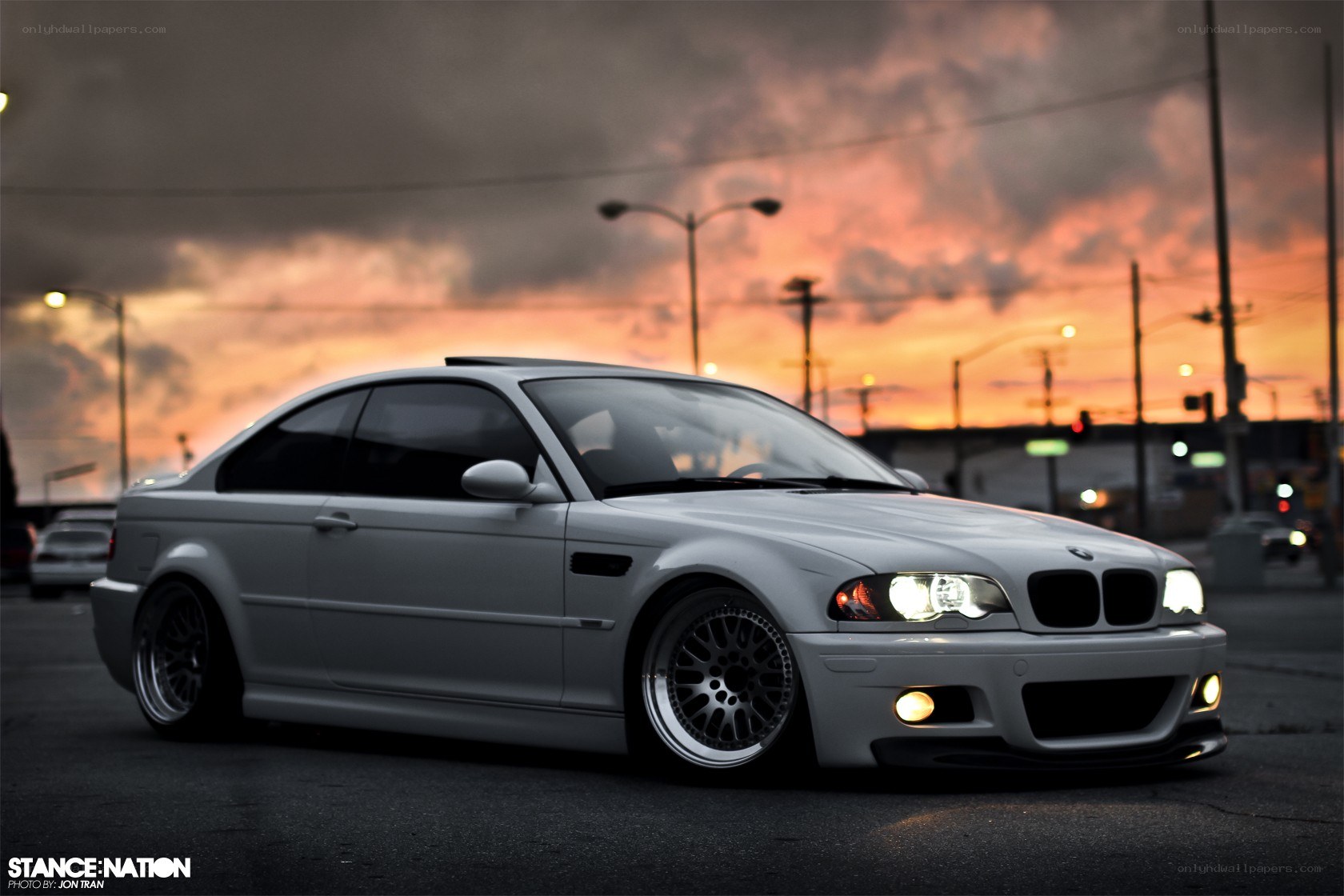 white bmw coupe at sunset