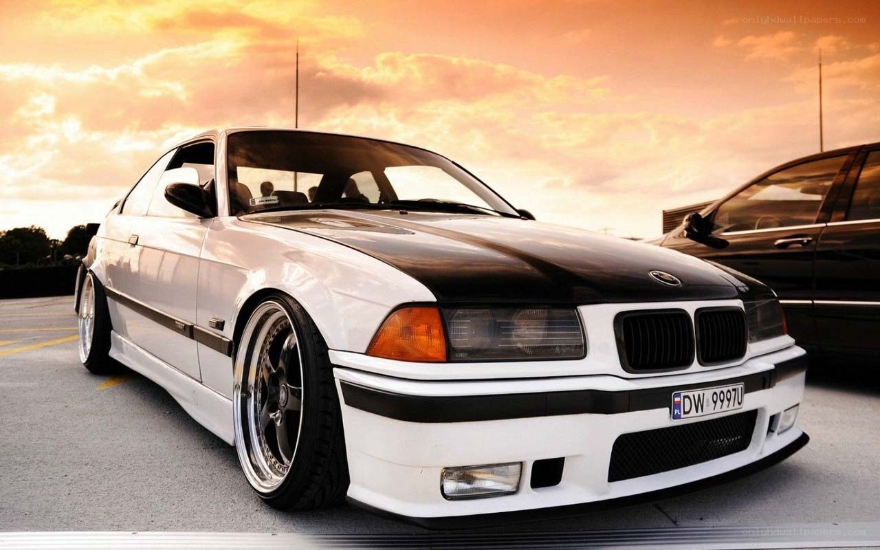 white bmw coupe at sunset
