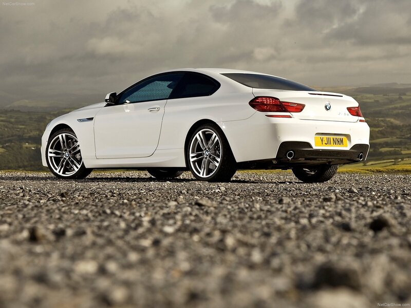 white bmw coupe on gravel