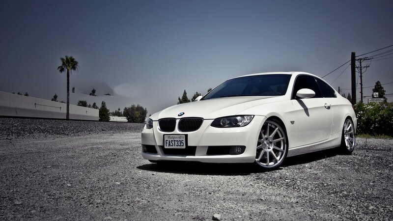 white bmw coupe on gravel