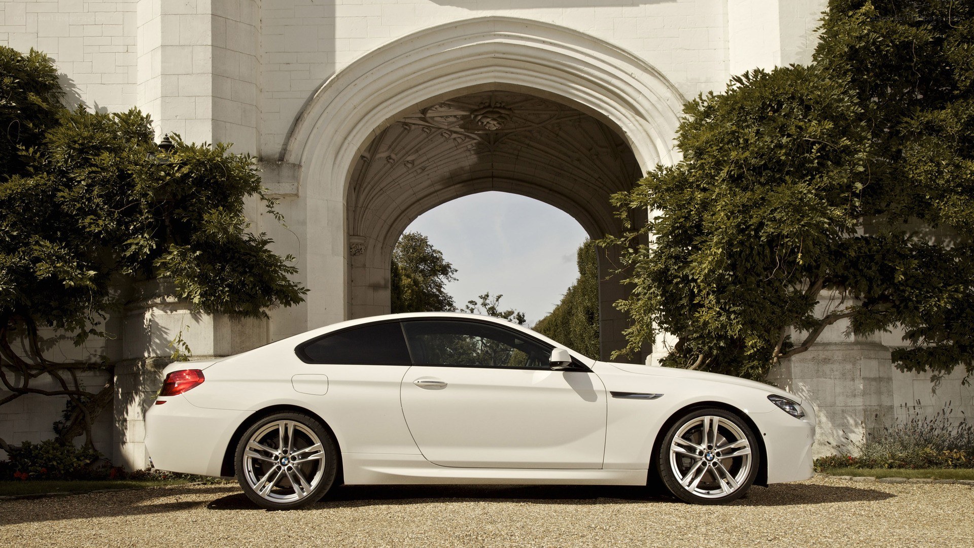 White BMW coupe under archway