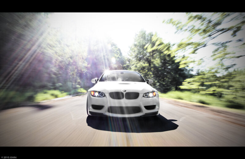 White BMW driving on a road