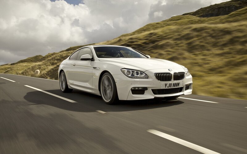 white bmw driving on road