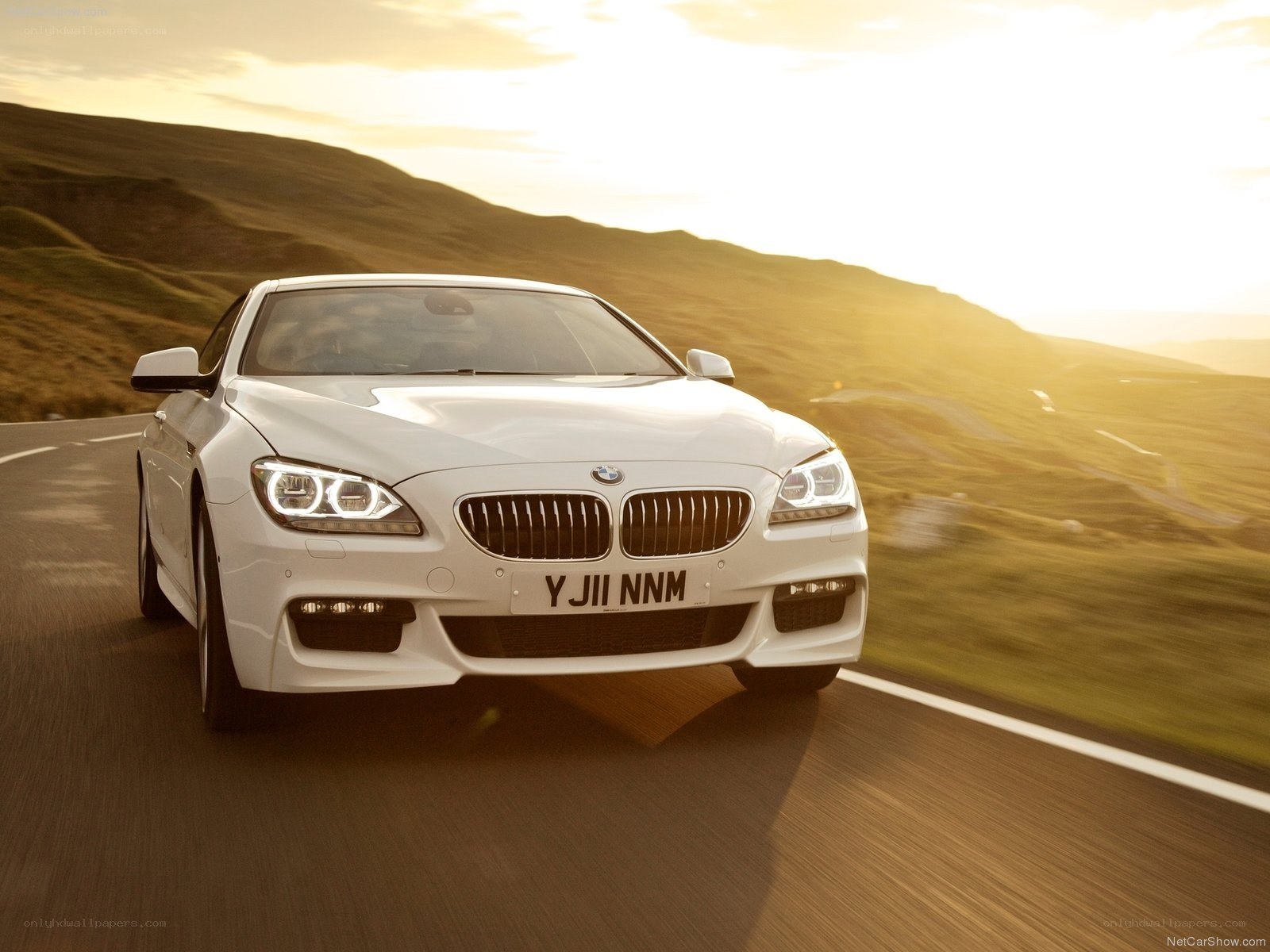 white bmw driving on road