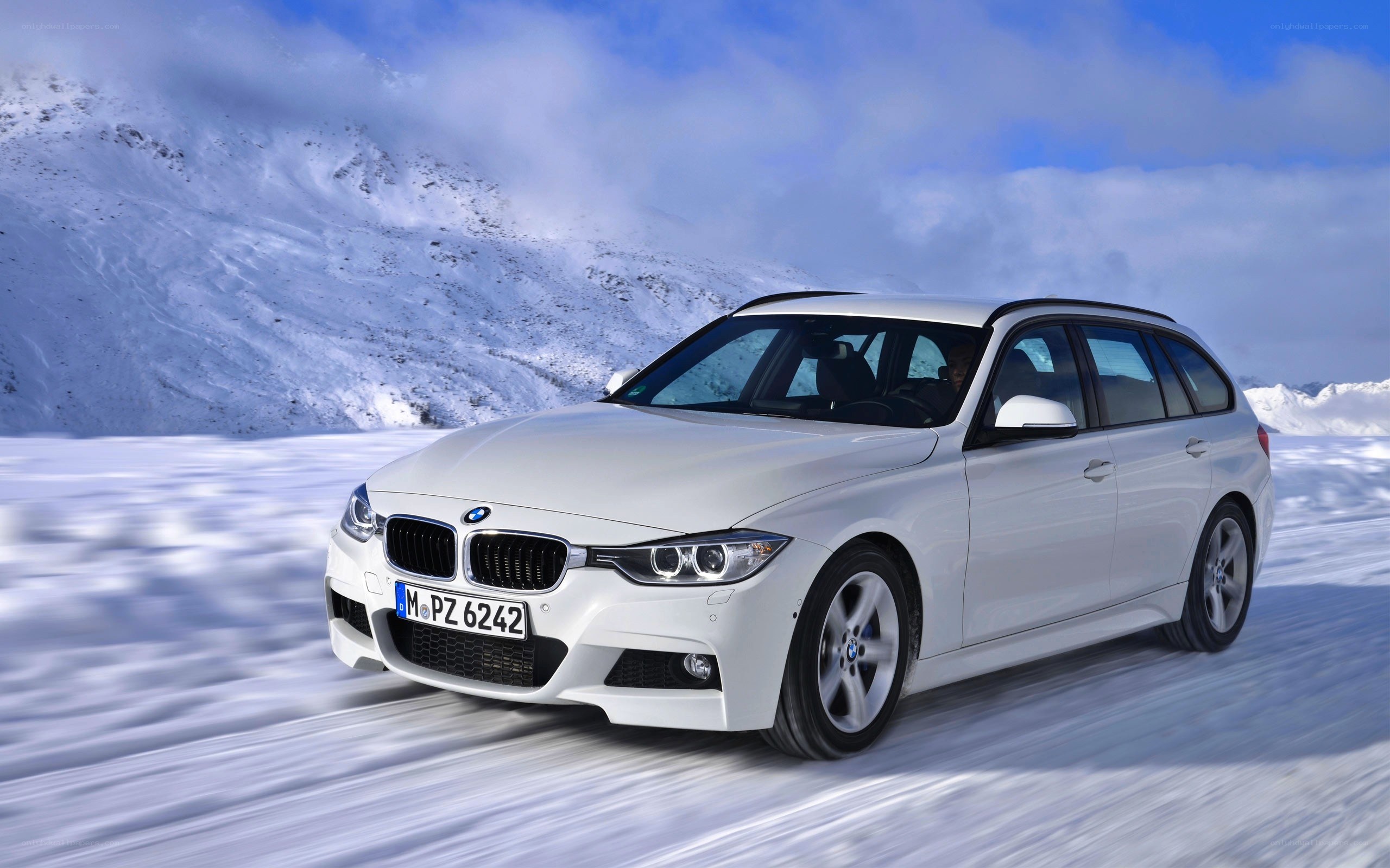 white bmw driving on snowy road