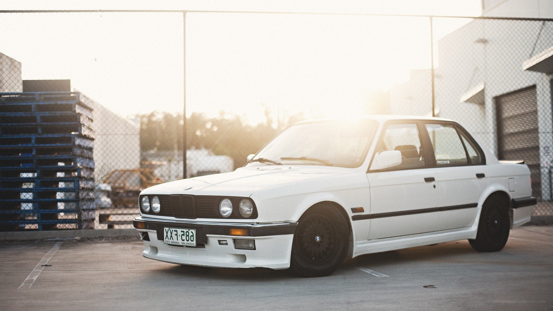 white bmw e30 in industrial lot