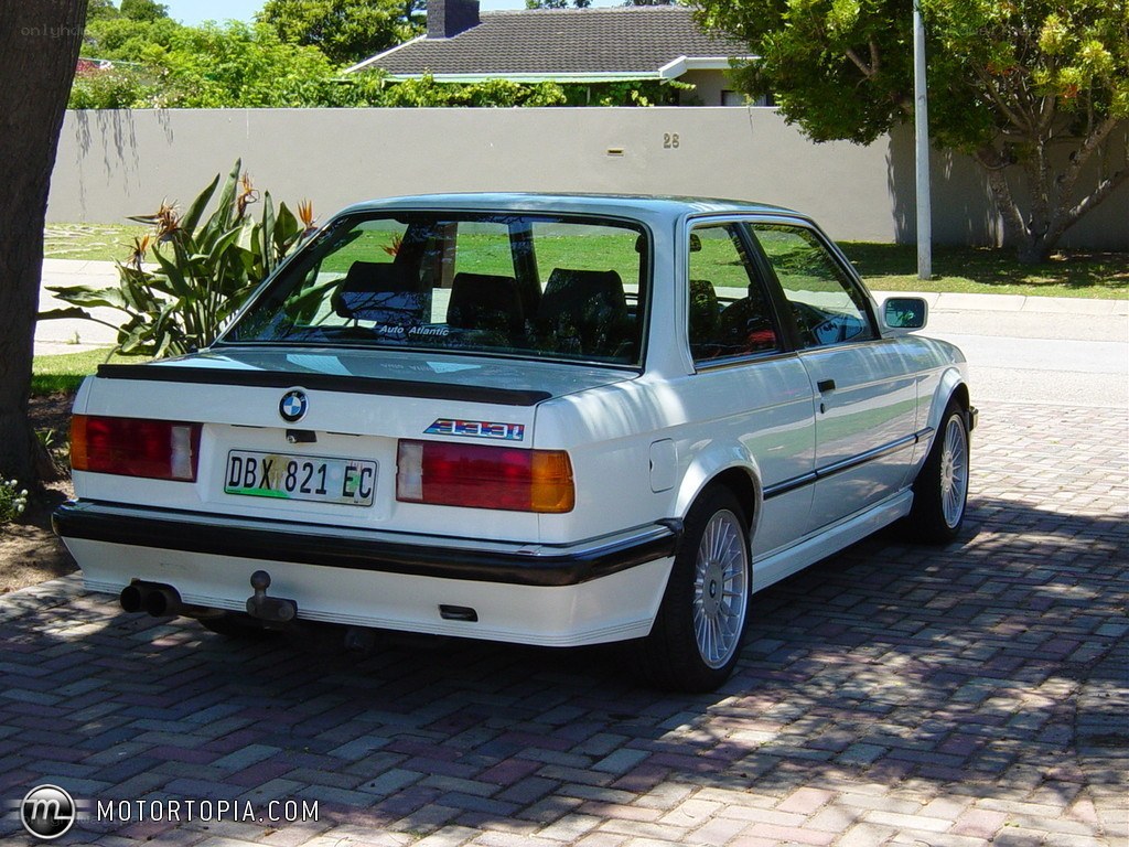white bmw e30 parked on driveway