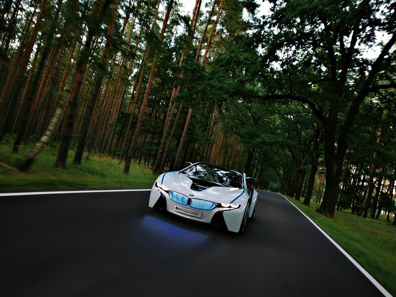 White BMW i8 driving on forest road