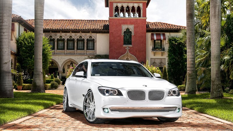 White BMW in front of mansion