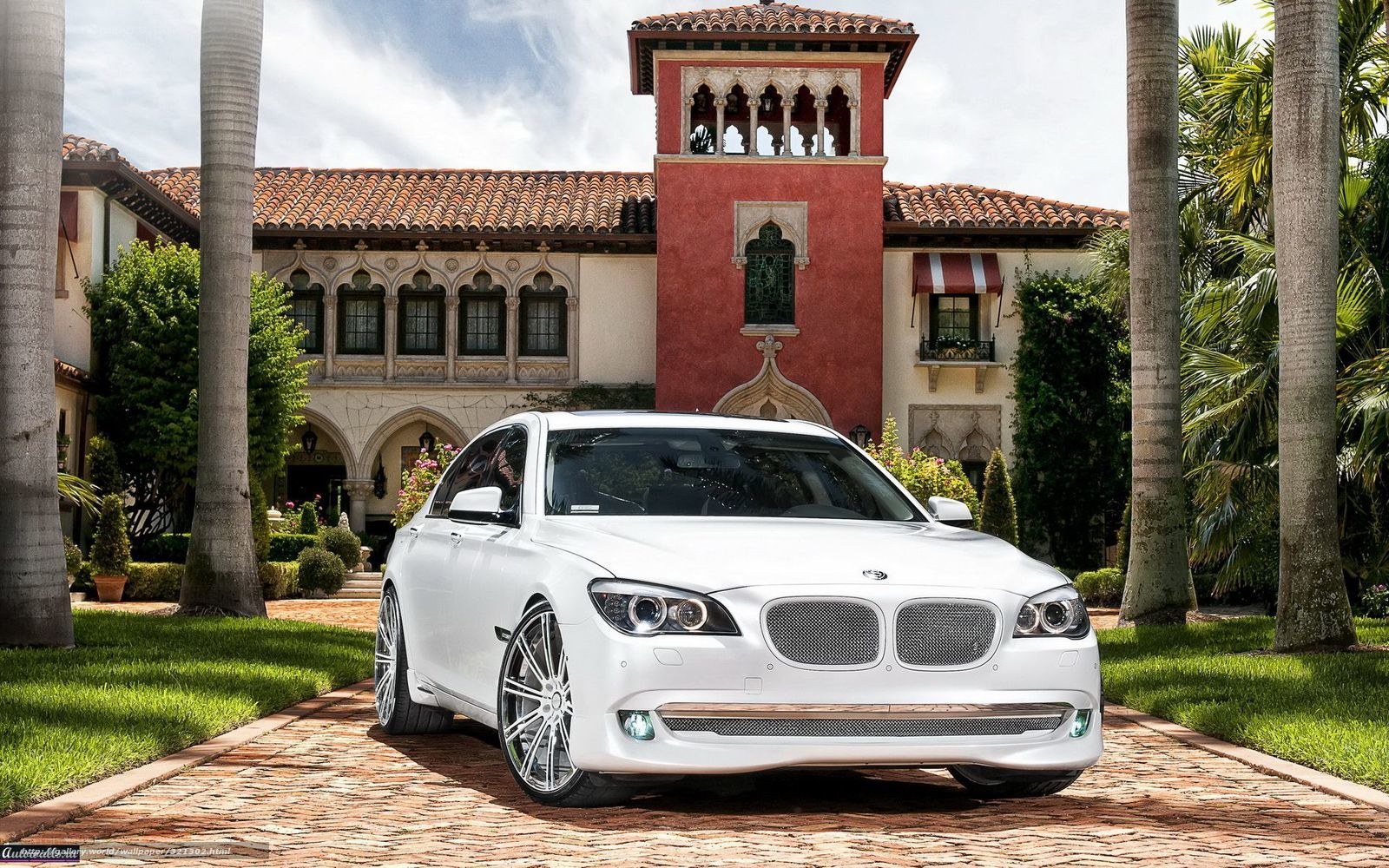 White BMW in front of mansion