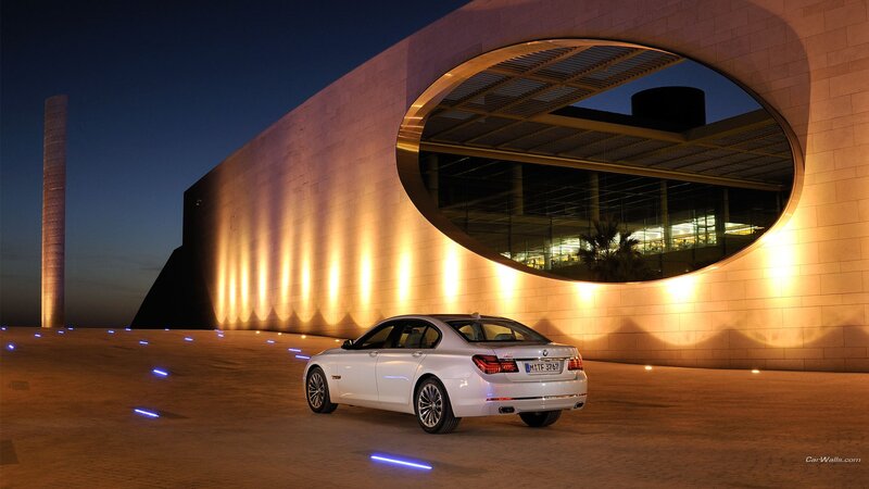 White BMW in front of modern building