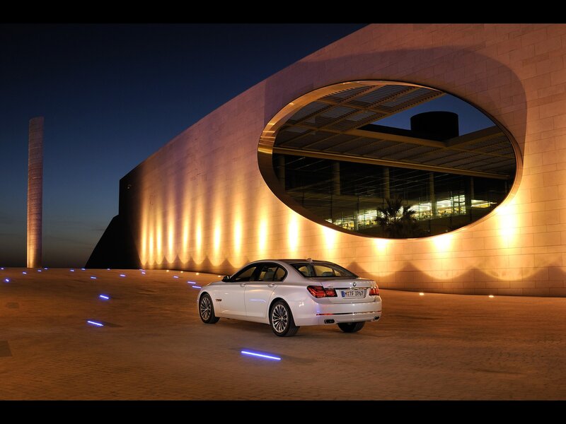 White BMW in front of modern building