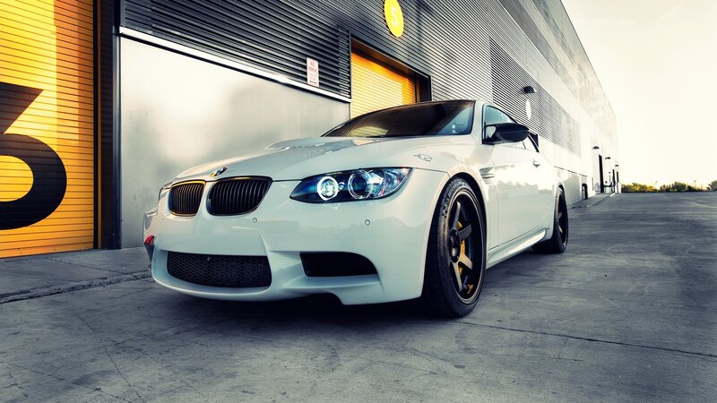 white bmw m3 in front of garage