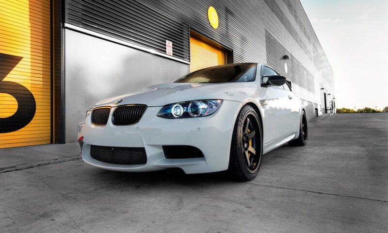 White BMW M3 in front of garage