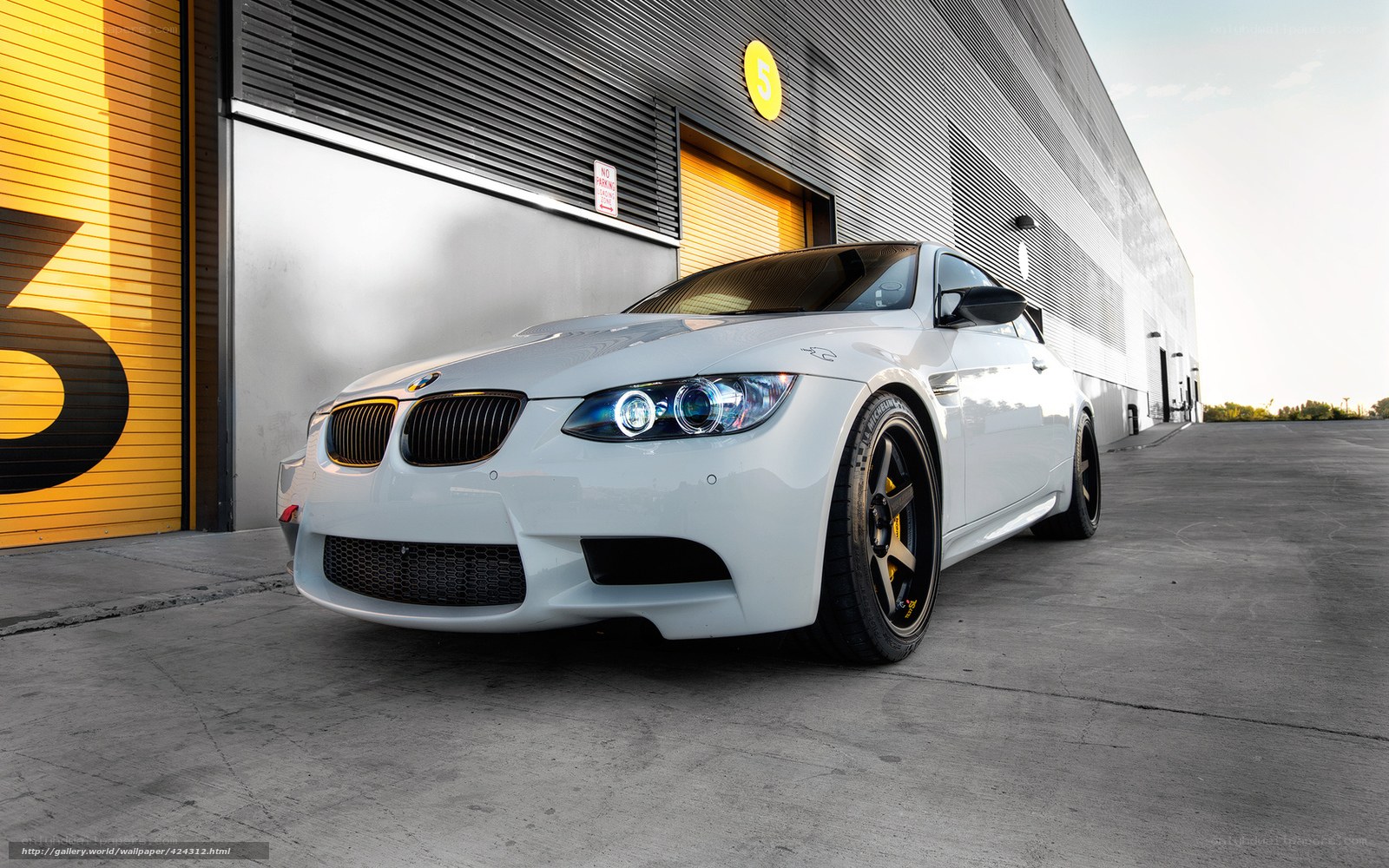 White BMW M3 in front of garage