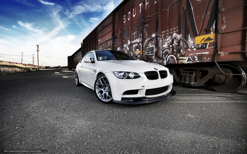 White BMW M3 near train car