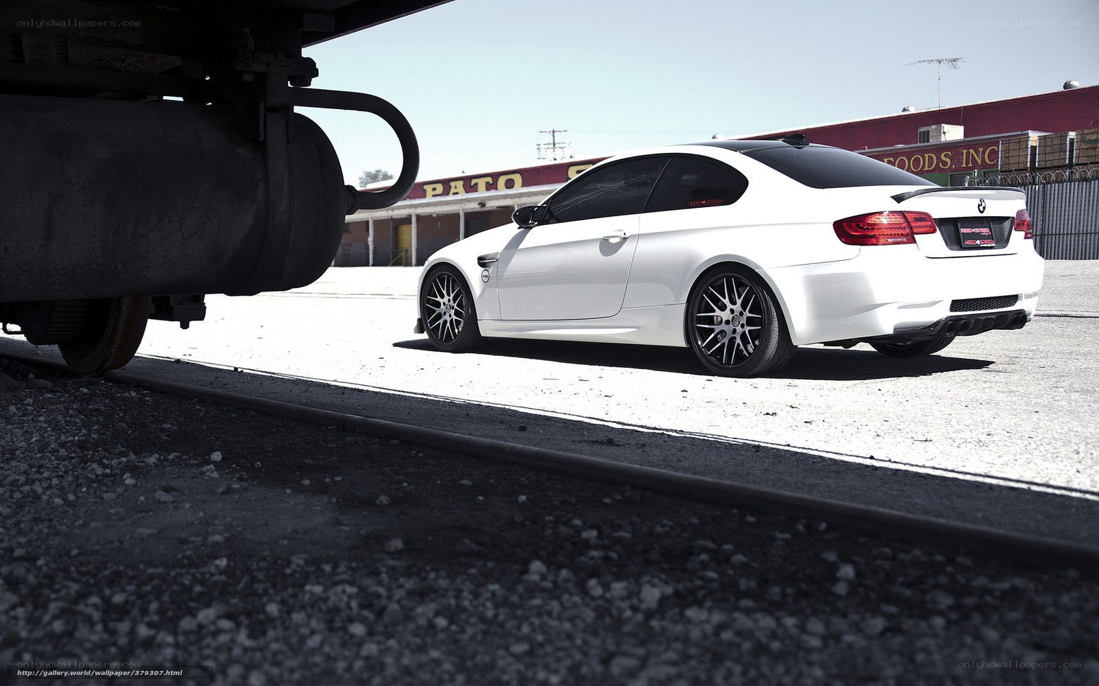 White BMW M3 near train tracks