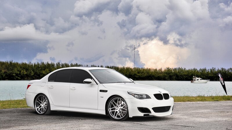 white bmw m5 by the water