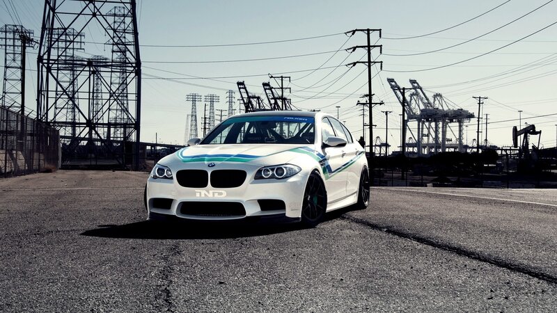 white bmw m5 on industrial lot