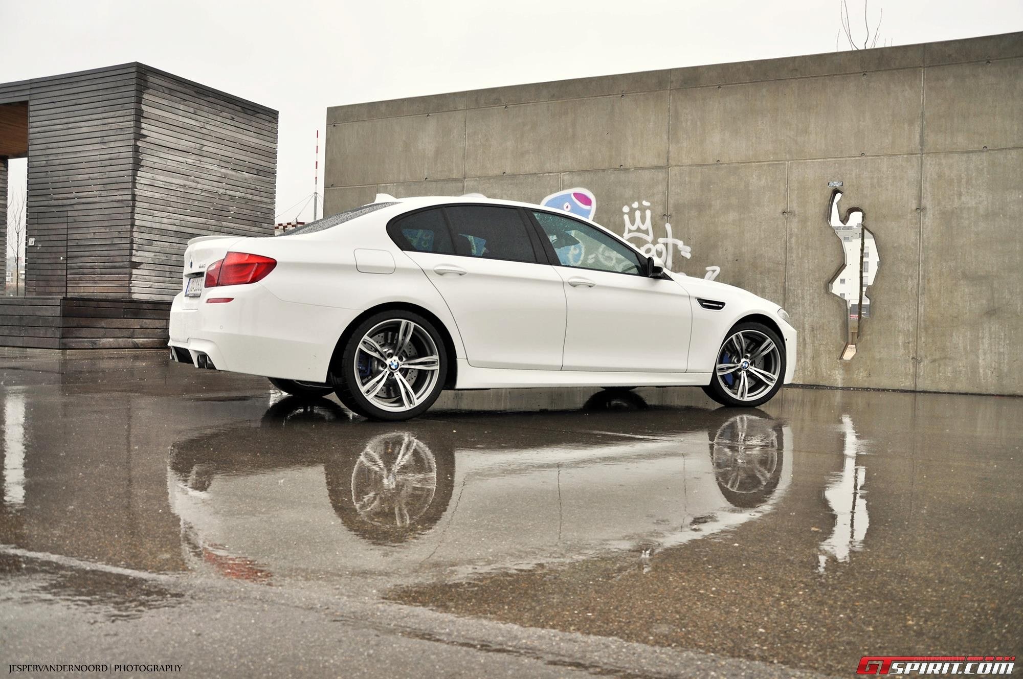 White BMW M5 on wet pavement