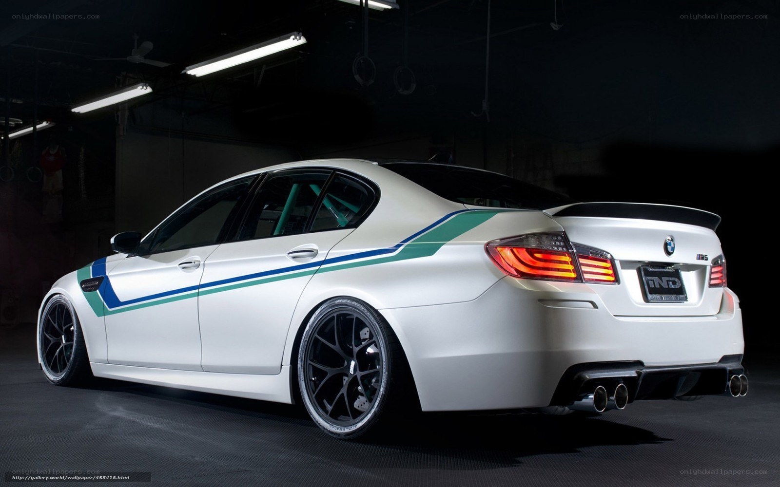 white bmw m5 with racing stripes