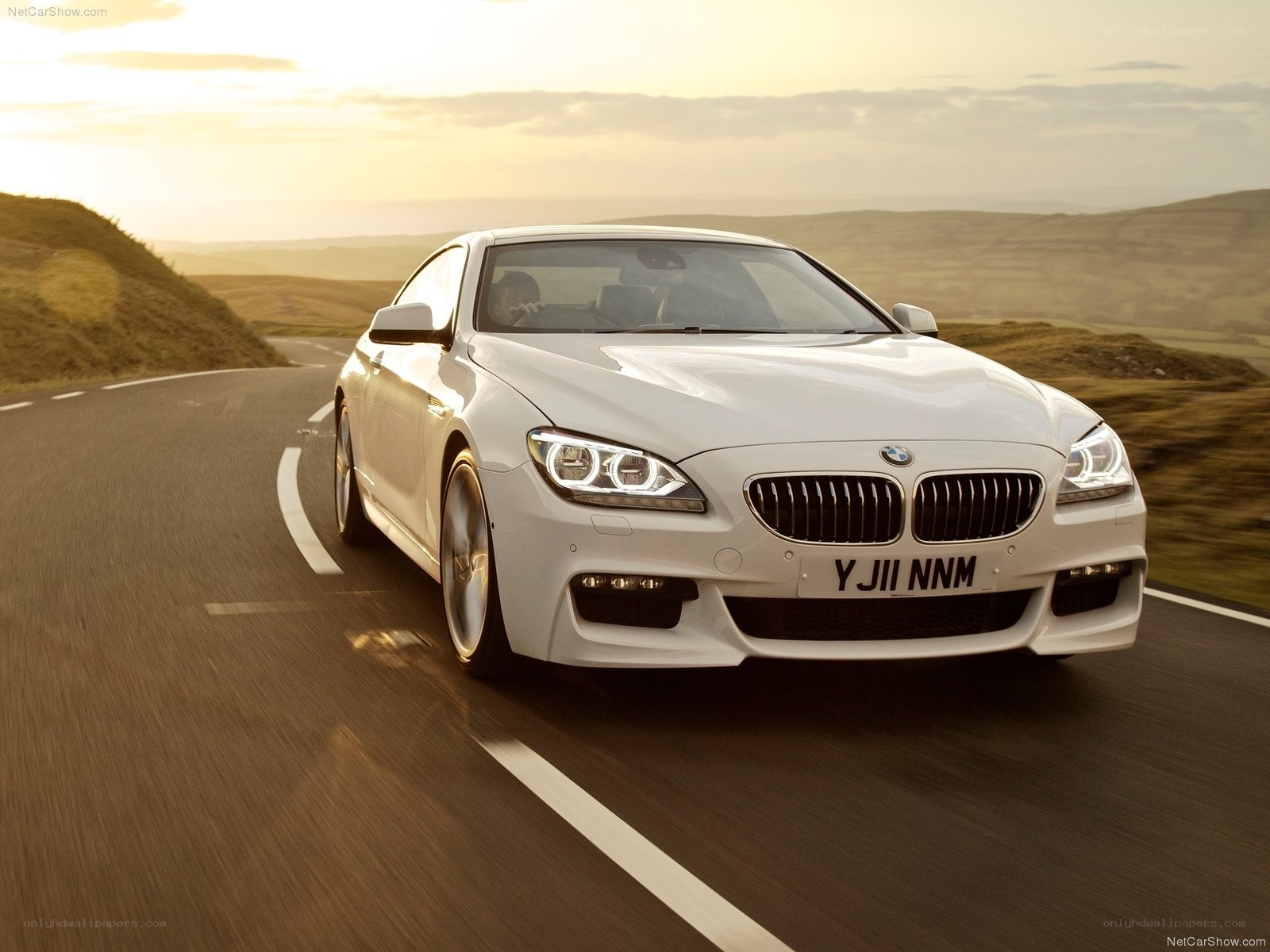 White BMW M6 driving on a road