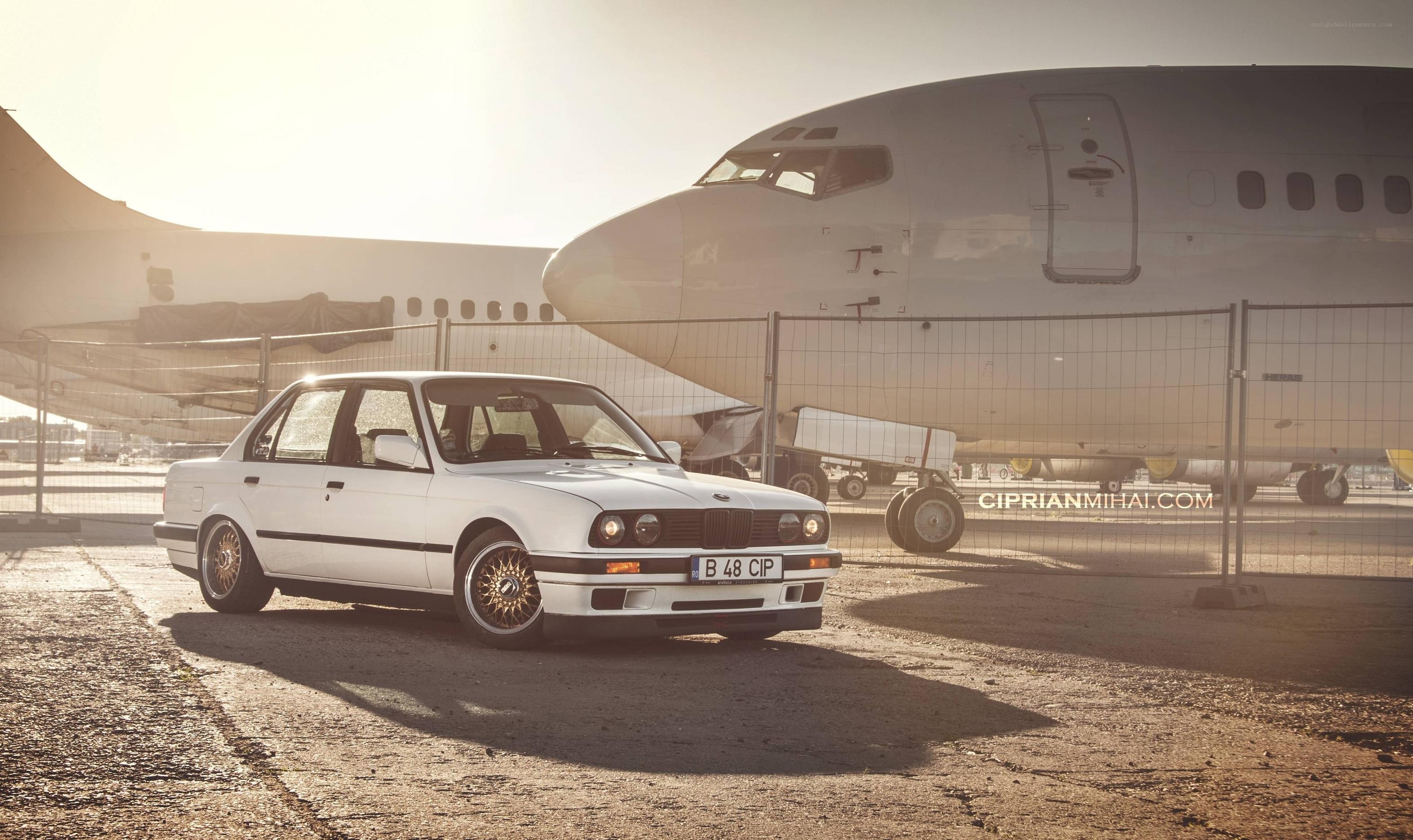 White BMW near airplane
