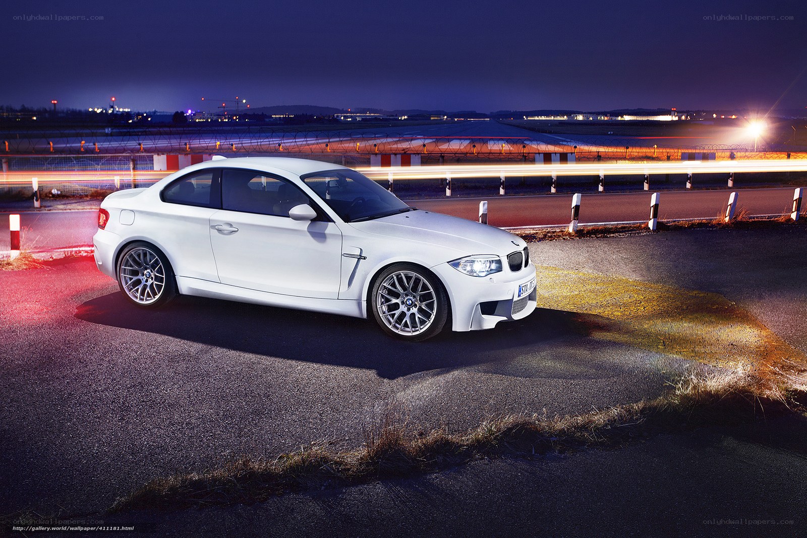 White BMW on a racetrack at night