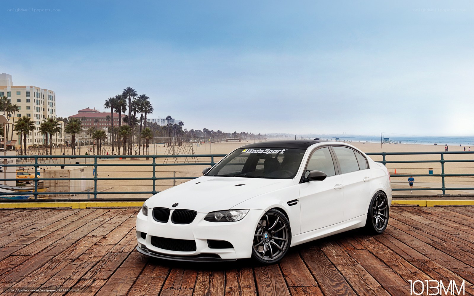 White BMW on a wooden pier